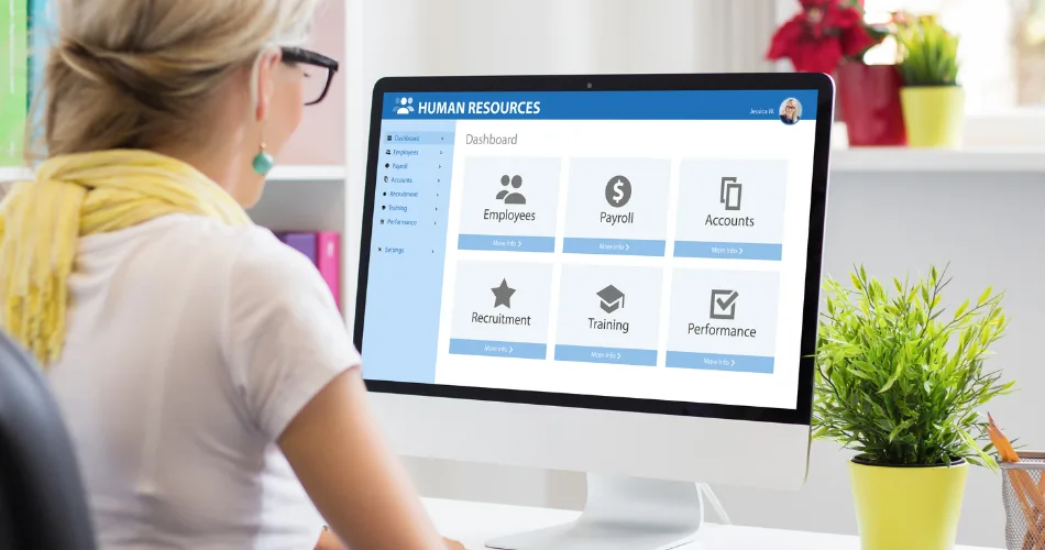 An HR professional looking at a human resources dashboard on the computer.