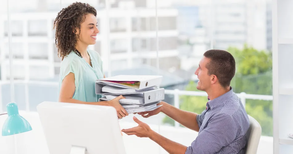 A woman handing projects to a team member.
