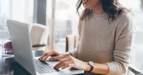 A woman writing a blog on a laptop.