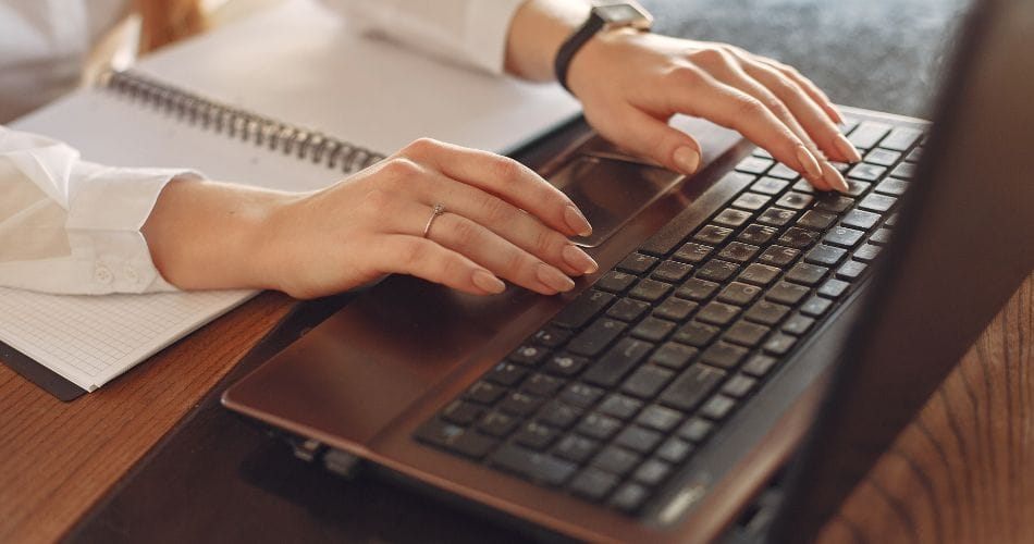 A human typing on a laptop