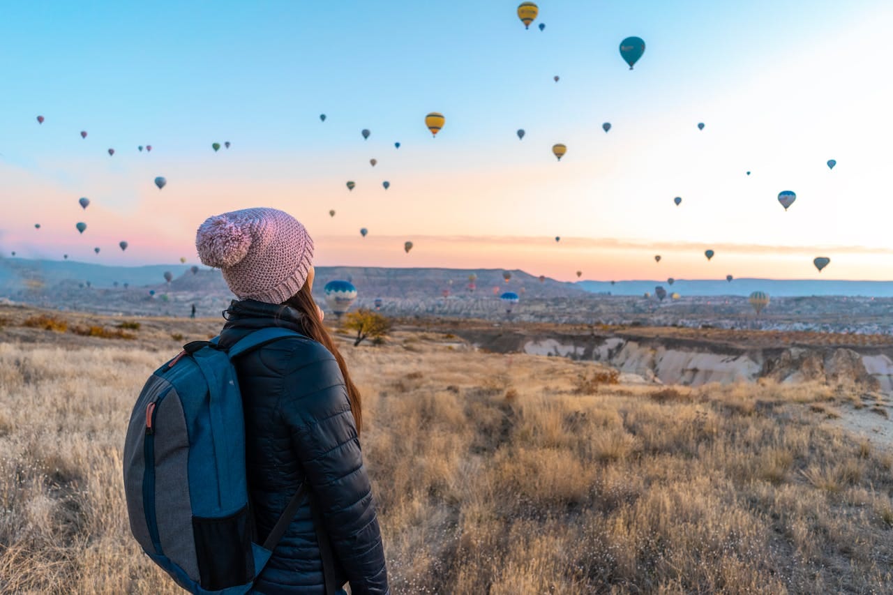 A woman watching hot air balloons